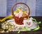 Easter basket with Easter eggs, decorative chicken with quail eggs on wooden background.