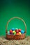 Easter basket with multicolor eggs, green background
