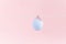 Easter blue flying eggshell, hanging on a rope with a wooden small clothespin on light pink background. Egg is symbol of