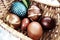 Easter boiled eggs of different colors dyed with onion peel and paint in wicker basket. Vegetable patterns on the shell