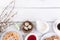 Easter breakfast with quail eggs, waffles, fruit jam, milk, coffee and sandwiches, with willow branch on a white wooden background