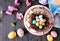Easter bundt cake with chocolate nest of colorful candy eggs, above view table scene