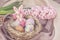 Easter bunnie in a natural bird`s nest with chocolate Easter eggs next to e spring flower. Easter holiday composition