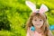 Easter bunny child boy with cute face. Kids hunting easter eggs. Children activity for Easter in nature.