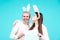 Easter bunny couple hold board paper for text. Family couple dressed in costume Easter bunny on blue background isolated