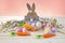 Easter bunny with easter eggs, carrot and willow and yellow ribbon. Festive Easter composition