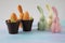 The Easter bunny hid behind flower pots with tulip buds from other funny and cheerful bunnies - a chocolate composition made of