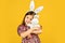 Easter bunny kid. small girl hold hare toy. happy childhood. cute child play with toy. toy shop concept. girl in funny