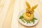 Easter bunny kids food concept. Warm pumpkin cream soup in fresh bun roll with herbs and pumpkin seeds in plate. Wooden