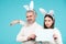 Easter bunny man and woman hold board board for text.