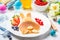 Easter bunny of pancakes with berries. Easter Breakfast table. Colored eggs, milk, juice and jam