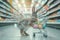 Easter bunny standing with shopping cart of Easter eggs in supermarket