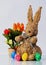 Easter bunny from straw with colored eggs and flower decoration