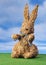 Easter bunny from straw sitting on grassland