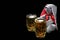 Easter bunny with two mugs of beer against black background