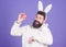 Easter bunny. White bunny symbol of easter. Guy with toy and easter egg on violet background. Enjoy tenderness. Spring