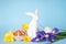 Easter cake, Easter bunny and eggs with flowers on a blue background. Happy Easter concept