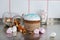 Easter cake with a white top, decorated with multi-colored sprinkles, glass jar with tangerine zest and marshmallows on kitchen