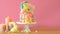 Easter candyland drip cake with white chocolate bunny in party table setting.