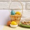 Easter card with basket and colored eggs, plate with holiday cookies and white empty paper card