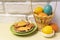 Easter card with basket with Easter colored eggs and plate with holiday cookies