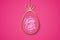 Easter celebrate banner with golden easter egg and handwritten holiday wishes of a Happy Easter on pink background.