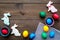 Easter celebration with colorful eggs and gingerbread in shape of easter bunny and carrot. Wooden background top view