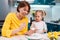 Easter celebration and traditions. Smiling mother and her toddler daughter painting eggs. Young woman teaching a little