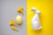Easter ceramic bunny with yellow easter egg andfreesia flower on a yellow-grey background, top view