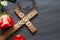 Easter christian wooden cross with an inscription god is love and red rose abstract religion background