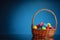 Easter color eggs in festive gift basket, blue background