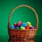 Easter color eggs in festive gift basket, green background