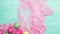 Easter colored eggs in a pink cloth on mint green wooden background.