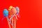 Easter colorful decorated eggs stand on a sticks on red background. Minimal easter concept. Happy Easter card with copy space for