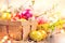 Easter colorful eggs in the basket. Beautiful colorful yellow, pink and orange color eggs with decorations and spring flowers