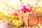 Easter colorful eggs in the basket. Beautiful colourful yellow, pink and orange color eggs with decorations and spring flowers