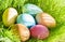 Easter colorful eggs in spring green grass in sunlight floral abstract background