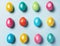 Easter composition of brightly multicolored painted glossy Easter eggs laid out on light blue pastel background