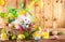 Easter composition with bunny in basket, spring flowers and colorful Easter eggs
