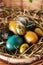 Easter composition. Cute painted easter eggs  are placed on nice haystack from dried straws and inside wicker basket. Greeting