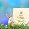 Easter composition in a light blue hue with a square frame, eggs and rabbit ears, spring flowers with willow twig and