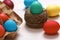 Easter composition. Multi-colored eggs in a box, in a nest of hemp threads, on a white table