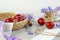 Easter composition: painted eggs on a decorative tray among lace and ribbons, blue flowers and poppy branches, light background