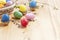 Easter composition - several colored eggs in a basket and on a light wooden table with willow twigs, place for text