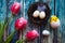 Easter composition - tulips, toy chicken and nest with eggs on wooden background