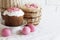 Easter composition with wicker basket with pink colored eggs and decorated Easter cake