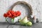 Easter composition with wooden wreath, red tulips, ceramic hens