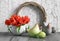 Easter composition with wooden wreath, red tulips, ceramic hens and painted eggs