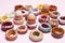 Easter concept. Collection of decorative handmade ceramic doughnuts / donuts and easter eggs on apple pink background
