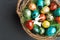 Easter concept with colorful quail eggs with white hare in basket